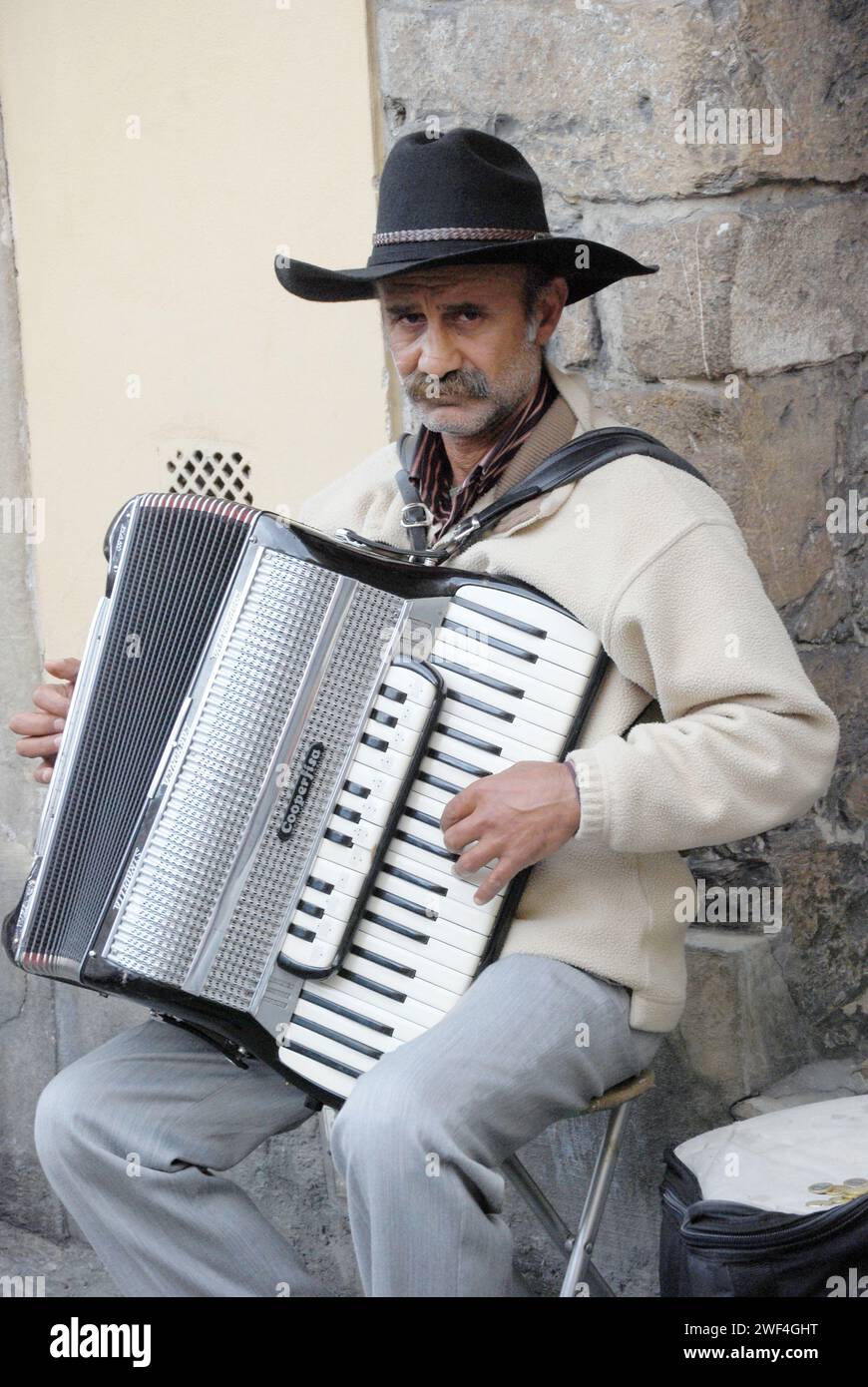 Ein Akkordeon, das einen Busker spielt, hält für ein Foto in Florenz, Italien Stockfoto