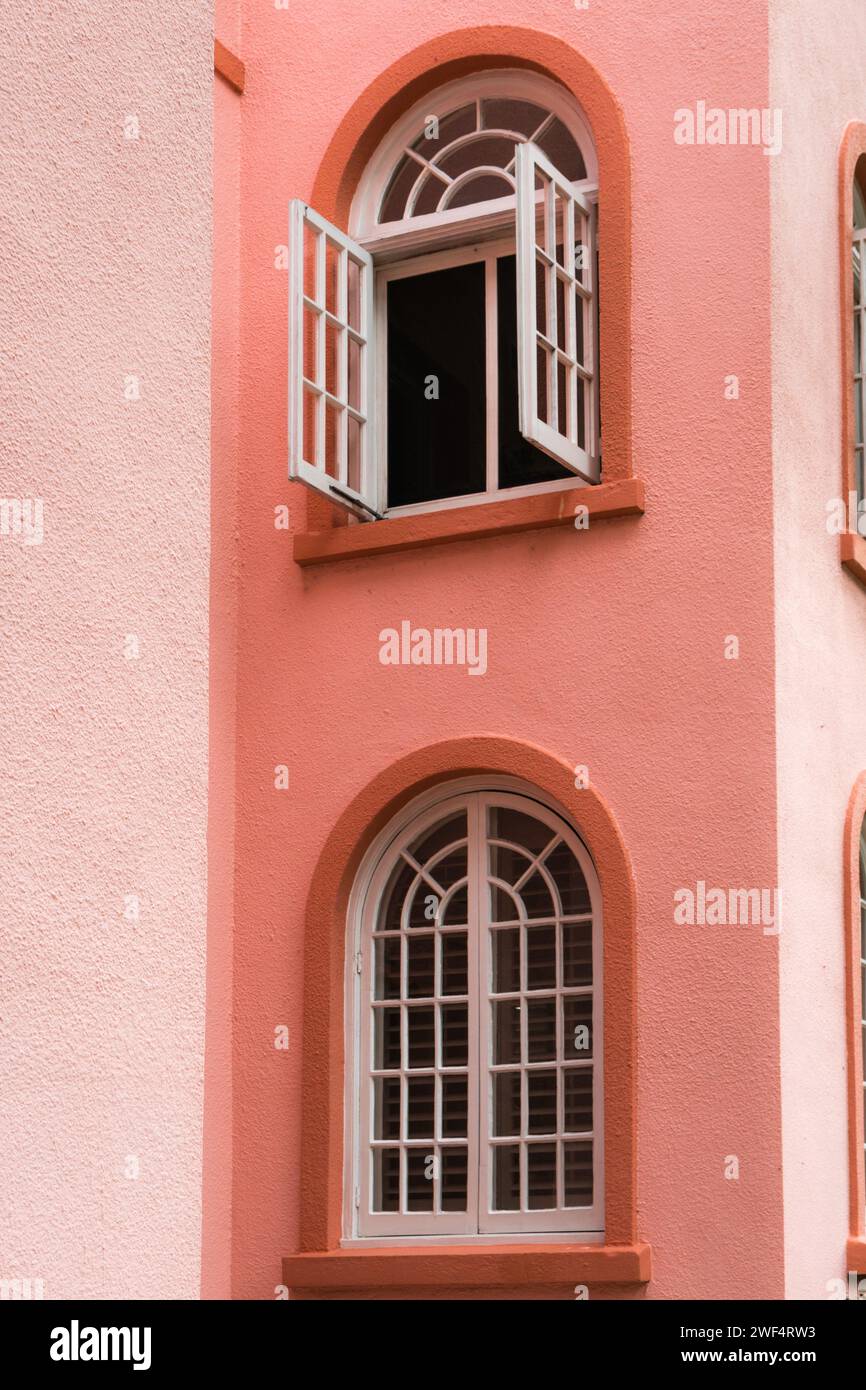 Pfirsichfarbenes Vintage-Gebäude mit Bogenfenstern und Türen in pfirsichfarbenem Fuzz. Stockfoto