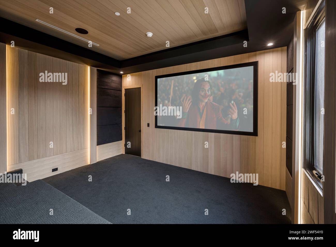 Gemütliches Home Entertainment-System mit bequemen Sofas und einem großen Bildschirm für ein ultimatives Kinoerlebnis Stockfoto