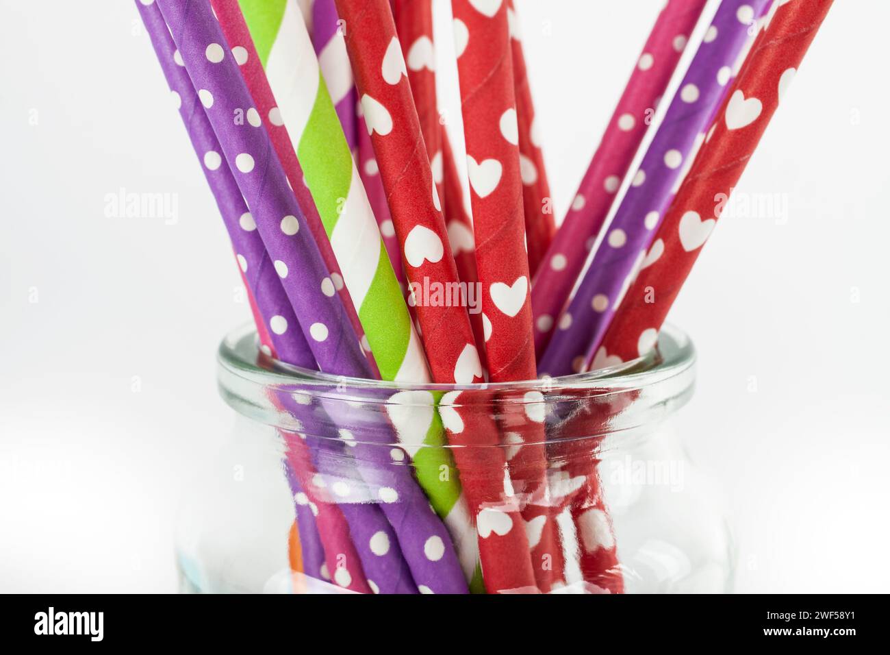 Bunte Papierhalme in einem Glas isoliert auf weißem Hintergrund Stockfoto