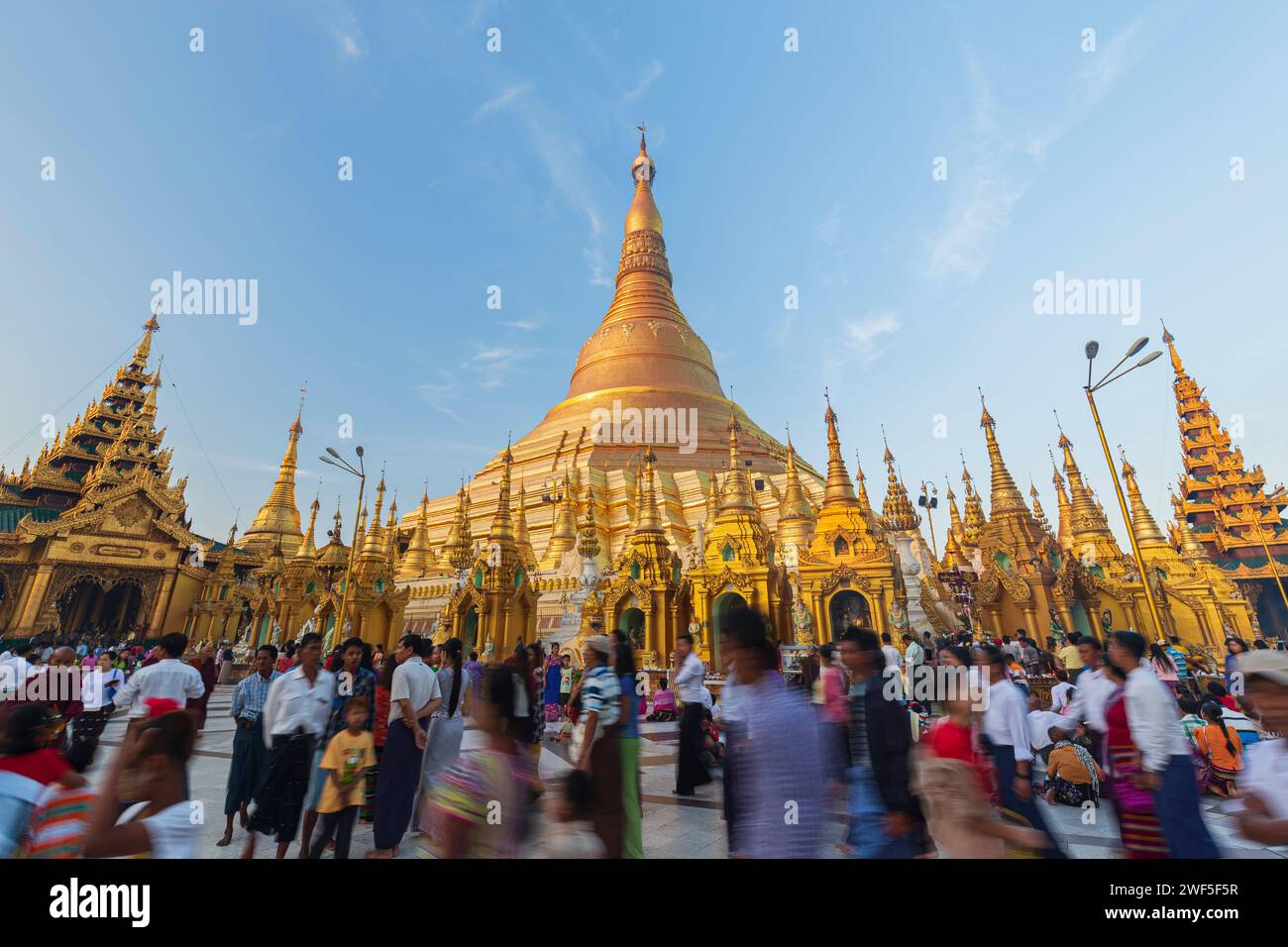 Viele Einheimische vor der vergoldeten Shwedagon-Pagode in Yangon, Myanmar, an einem sonnigen Morgen. Stockfoto