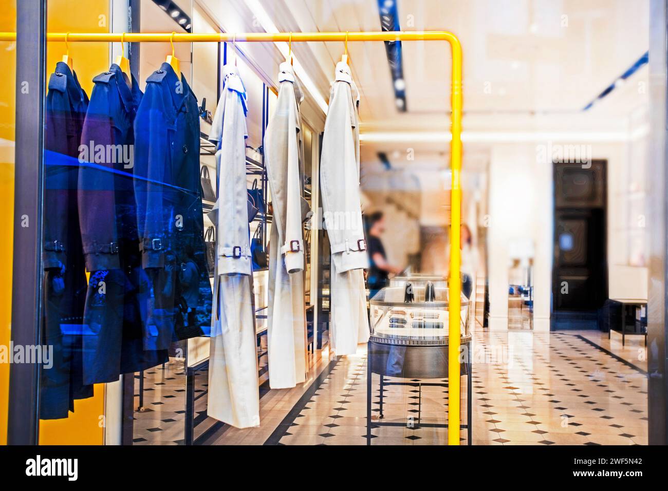 Stilvolle Oberbekleidung am Kleiderbügel in hellen und blauen Tönen im Geschäft Stockfoto