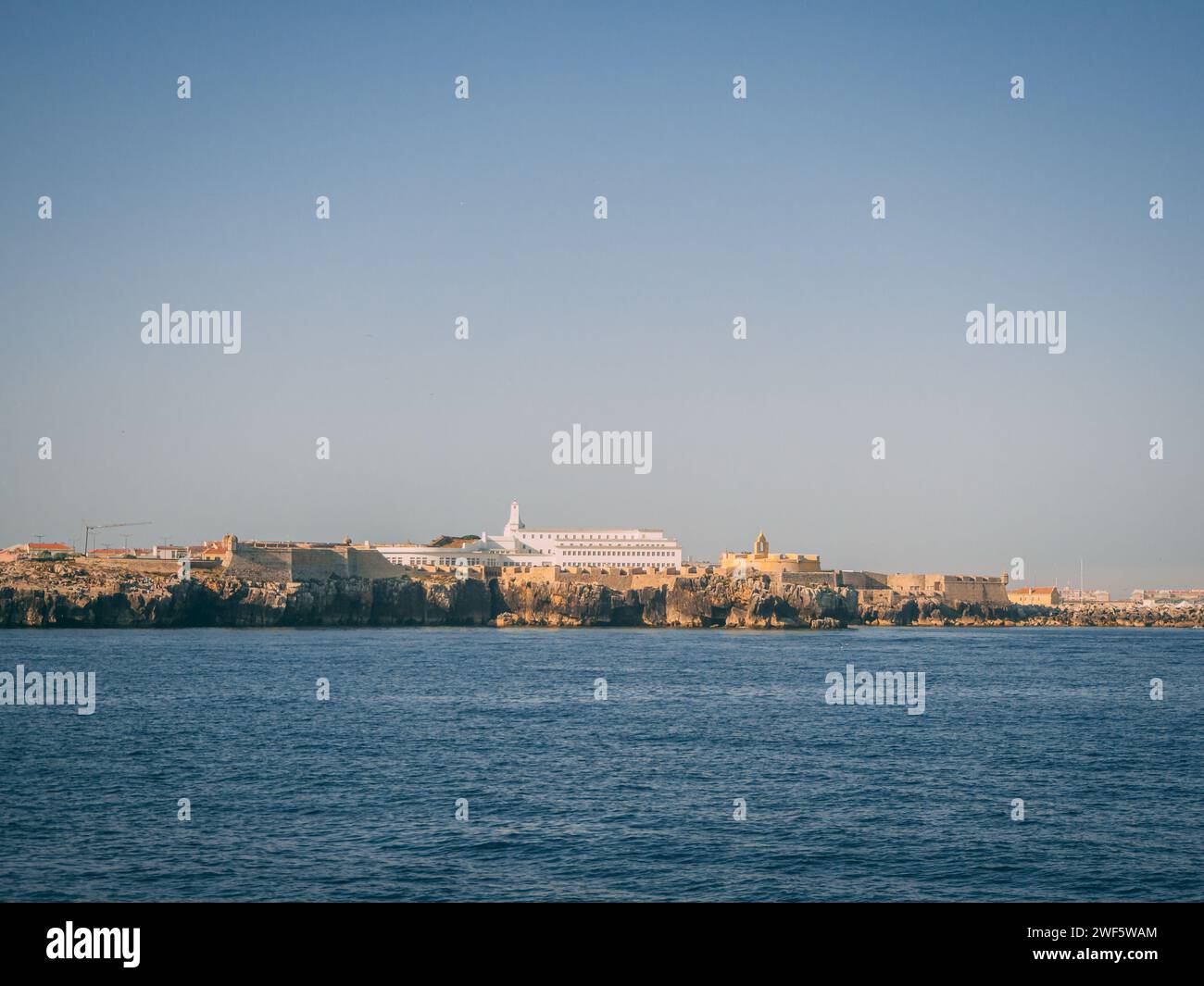 Zerklüftete felsige Küste und farbenfrohe Häuser im Zentrum von Peniche in Portugal Stockfoto
