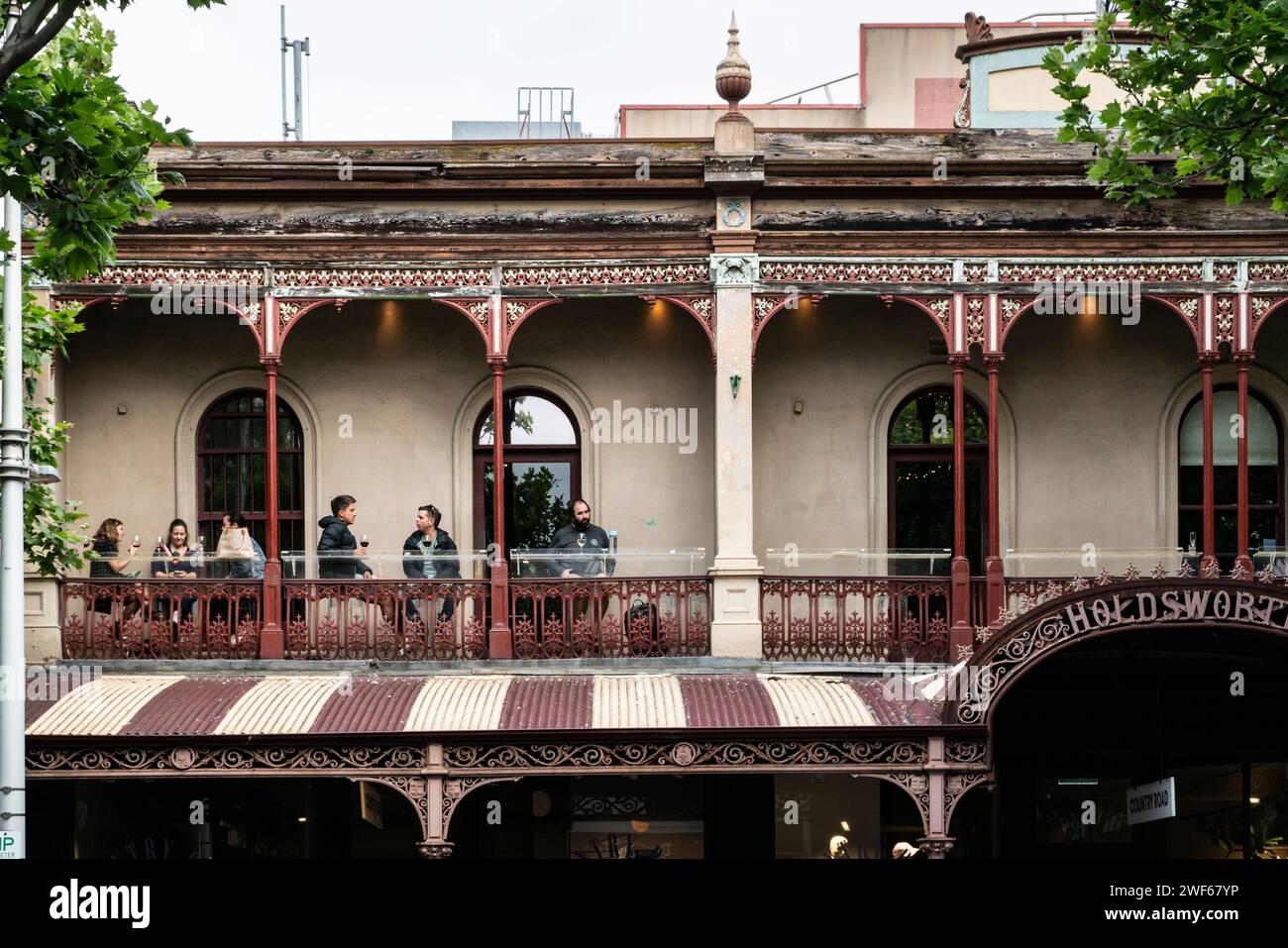Gruppe von Menschen, die auf einer Terrasse in einem Pub in der Lygon Street, Melbourne, Victoria, Australien trinken Stockfoto