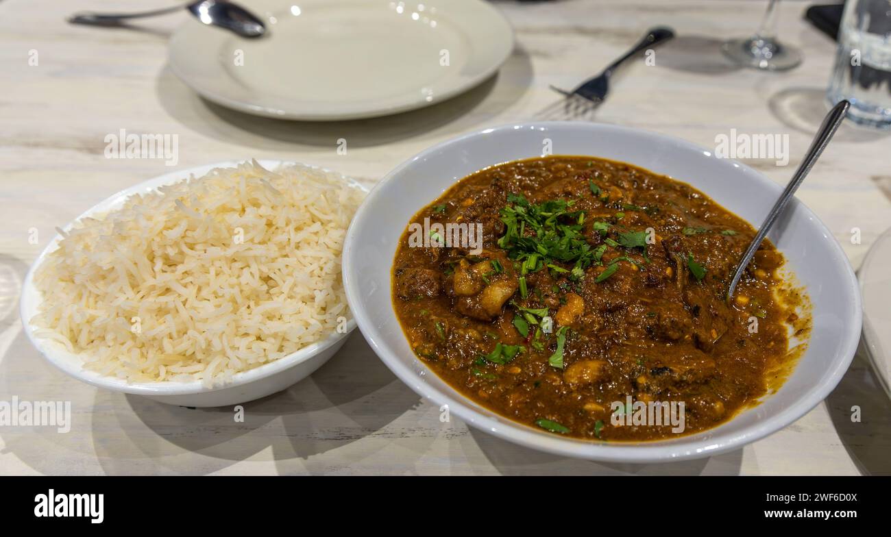 Indisches Essen. Hähnchensaat und Reis auf weißen Tellern Stockfoto