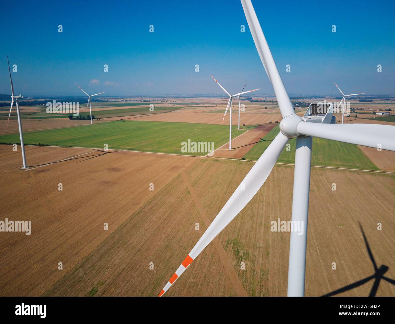 Luftaufnahme von Windkraftanlagen im ländlichen Raum, Windkraftanlagen in landwirtschaftlicher Landschaft, Konzept für grüne Energie aus erneuerbaren Quellen Stockfoto