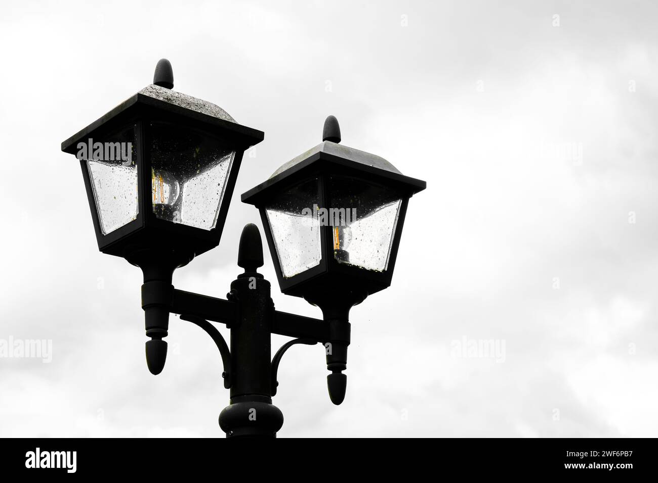 Schwarze rustikale Laterne vor grauem bewölktem Himmel. Stockfoto