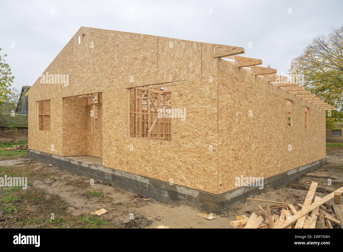 Vorgefertigte Baustelle aus Holzhäusern, Holzbalkenbalken und Holzspanplatten, selektiver Fokus Stockfoto