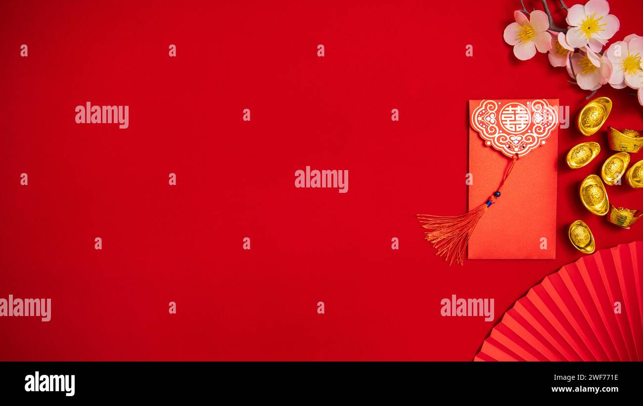 Flache Lage chinesischer Mondneujahrshintergrund. Roter Umschlag, ang Pow für das Geldspenden am chinesischen Neujahrsfest mit alter chinesischer Goldbarre Stockfoto