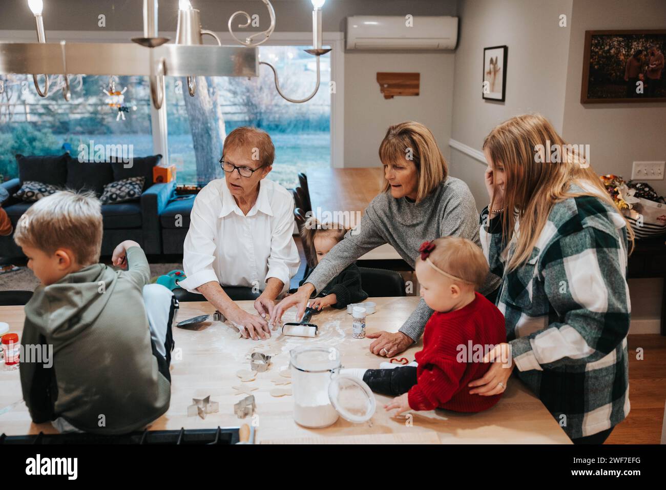 Drei Generationen schneiden Zuckerkekse aus, Küchengenuss Stockfoto