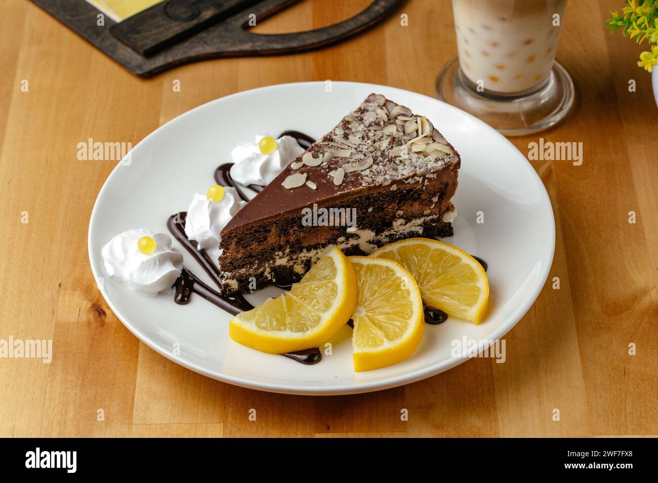 Schokoladenkuchen auf einem Teller und Zitronen daneben Stockfoto