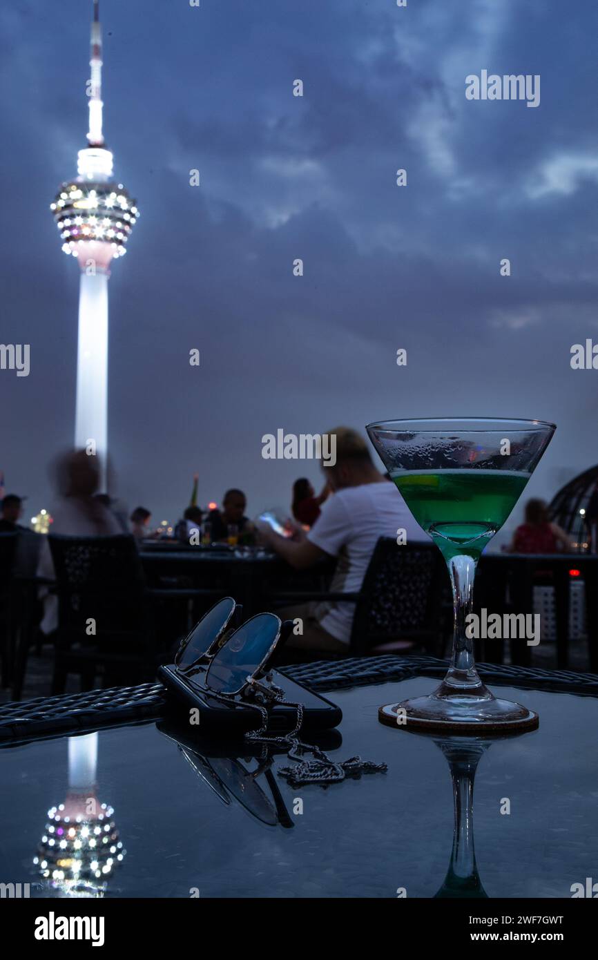 Grüner Cocktail, neben iphone und Sonnenbrille, in der Bar auf dem Dach Stockfoto