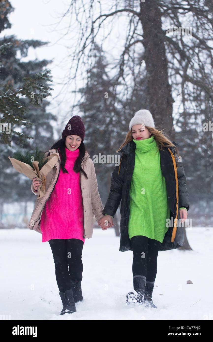 Im Winter spazieren Freundinnen durch den Park Stockfoto