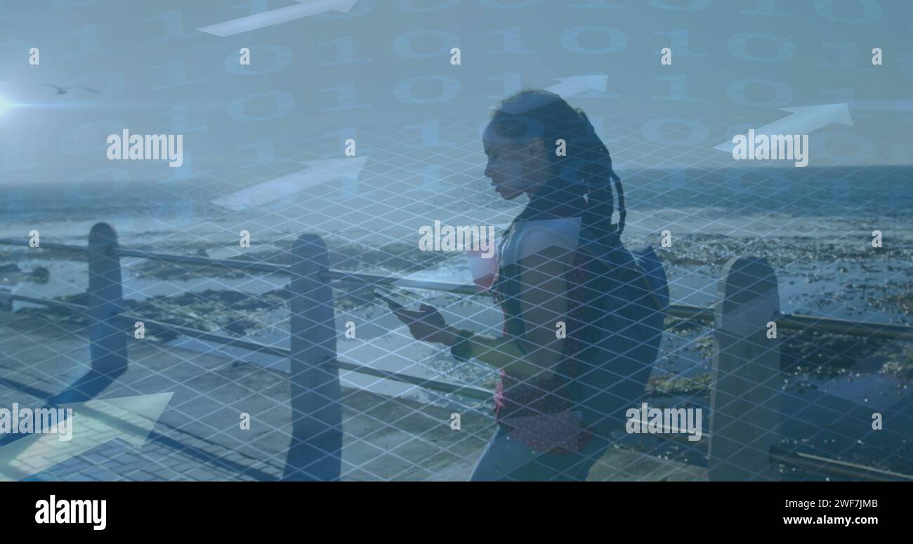 Bild von der Verarbeitung binärer Daten über Frau, die mit dem Smartphone läuft und am Meer trainiert Stockfoto