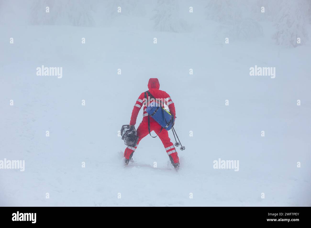 Sanitäter auf Skiern mit medizinischer Ausrüstung Skifahren in den Bergen im Winter während des Schneesturms. Themen retten bei extremen Wetterbedingungen. Stockfoto