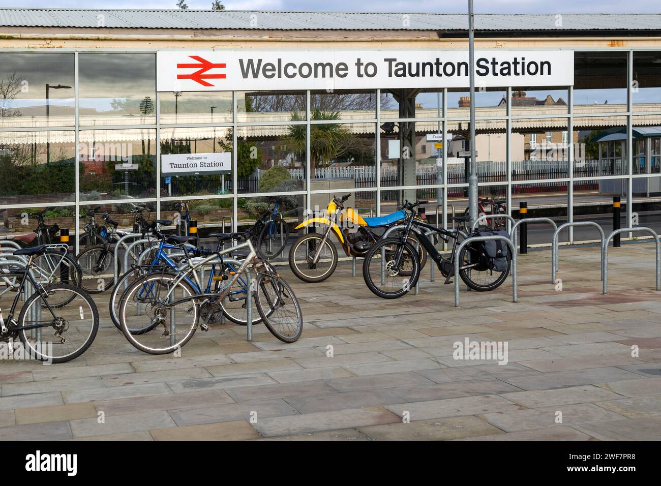 Fahrräder am Bahnhofsschild, Taunton, Somerset, England, Großbritannien - Willkommen am Bahnhof Taunton Stockfoto