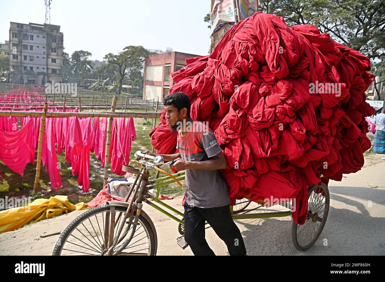 28. Januar 2024, Dhaka, Dhaka, Bangladesch: 29. Januar 2024 – NARAYANGANJ – Ein Arbeiter aus Bangladesch sammelt in einer Färberei in Narayanganj, nahe der Hauptstadt von Dhaka, gestrichene Stoffe, nachdem sie unter der Sonne getrocknet wurden. Die meisten Arbeiter leiden unter Hautkrankheiten durch ständigen Kontakt mit Chemikalien, die zum Färben des Gewebes verwendet werden, aufgrund des Fehlens geeigneter Vorsorgemaßnahmen. (Kreditbild: © Harun-or-Rashid/ZUMA Press Wire) NUR REDAKTIONELLE VERWENDUNG! Nicht für kommerzielle ZWECKE! Stockfoto