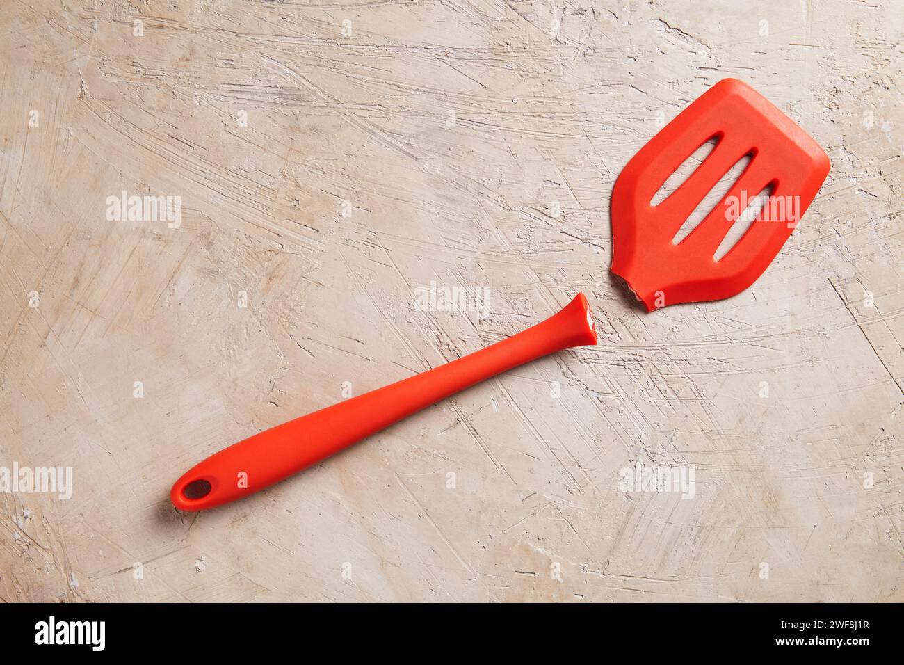 Ein gebrochener roter Spachtel auf strukturiertem Hintergrund Stockfoto