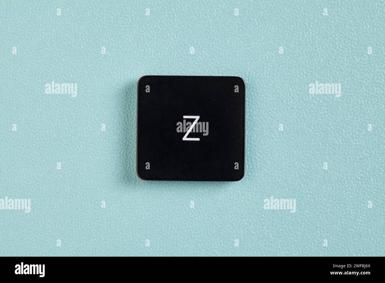 Eine Z-Taste mit einem Buchstaben, die von einer Tastatur mit blauem Hintergrund abgezogen wird Stockfoto