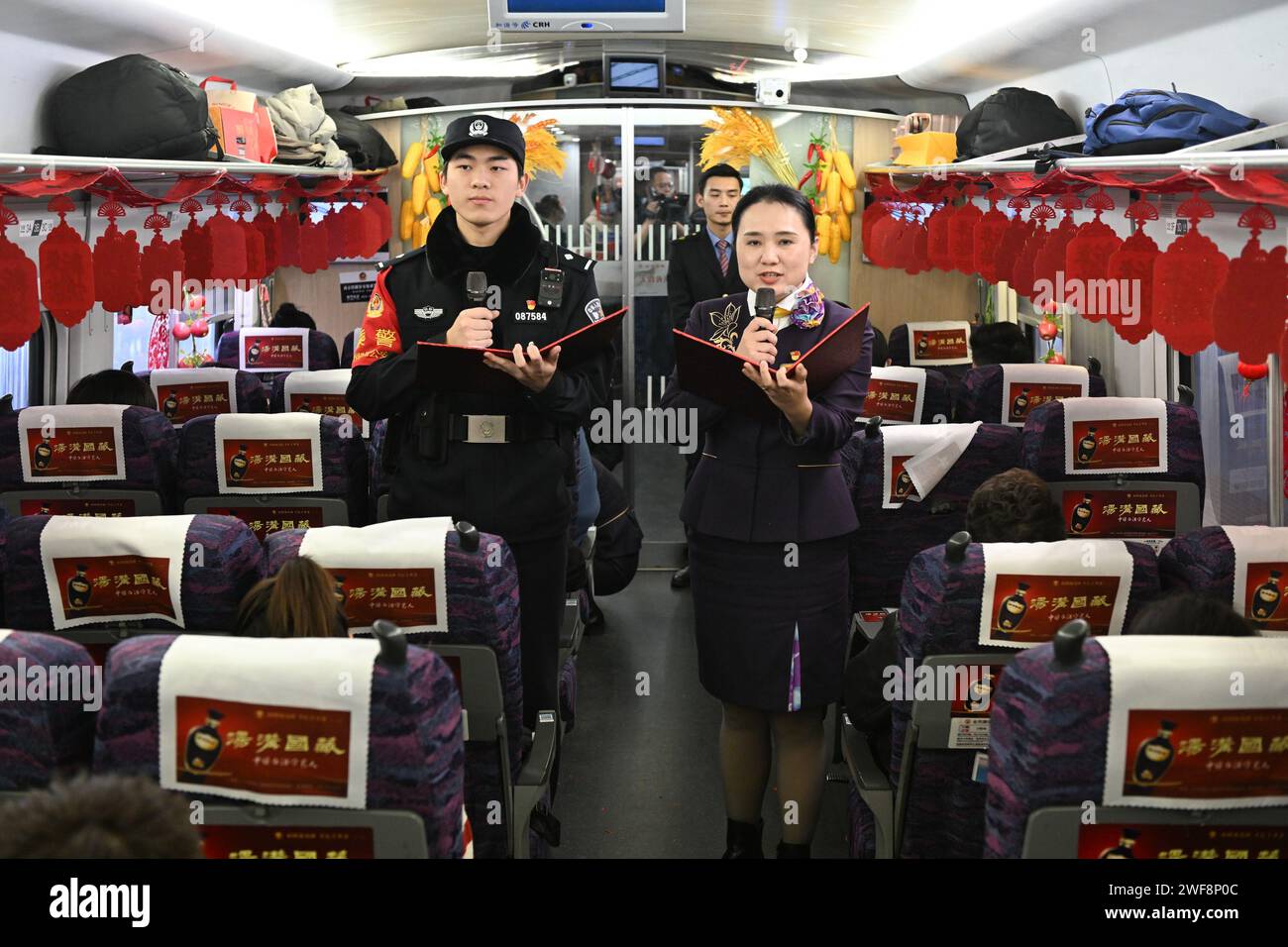 Nanjing. Januar 2024. Die Mitarbeiter führen ein Poesie-Konzert an Bord des Hochgeschwindigkeitszugs G7575 durch, 29. Januar 2024. Eine Reihe traditioneller kultureller Aktivitäten, wie Opernaufführungen und Papierschneidevorführungen, fand am Montag im Hochgeschwindigkeitszug statt. Am 26. Januar leitete China offiziell seine größte jährliche Bevölkerungswanderung ein. Der 40-tägige Reiseverlauf, auch bekannt als „Chunyun“, wird Hunderte von Millionen Menschen nach Hause zurückkehren und sich mit ihren Freunden und Familien wieder vereinen. Quelle: Ji Chunpeng/Xinhua/Alamy Live News Stockfoto