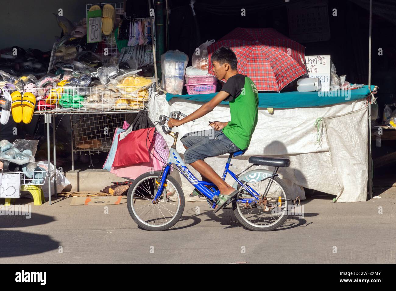 SAMUT PRAKAN, THAILAND, 07. Dezember 2023, Ein Mann fährt auf einem Fahrrad auf dem Marktplatz Stockfoto