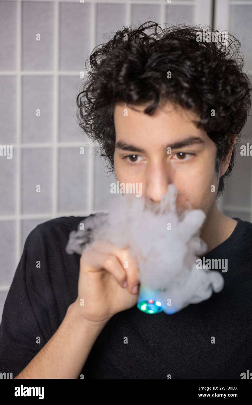 Großbritannien verbietet Einwegdampf (E-Zigaretten) zum Schutz der Gesundheit von Kindern. Teenager mit Einweg-Vapes und rauchenden Einweg-Vapes Stockfoto