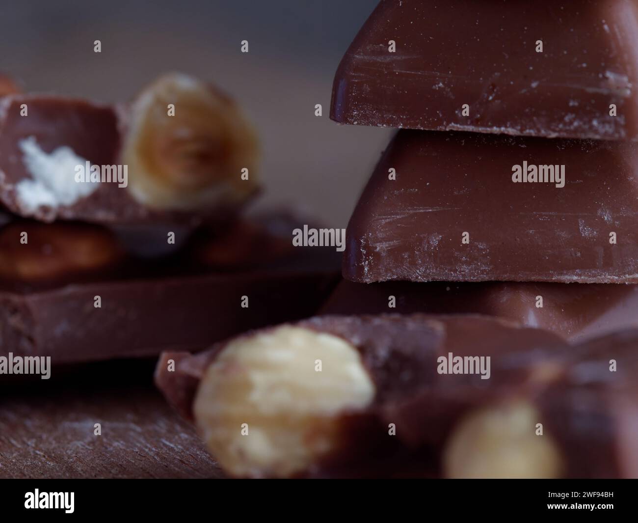Verschiedene Schokoladenbonbons und Nüsse auf einem rustikalen Holztisch Stockfoto