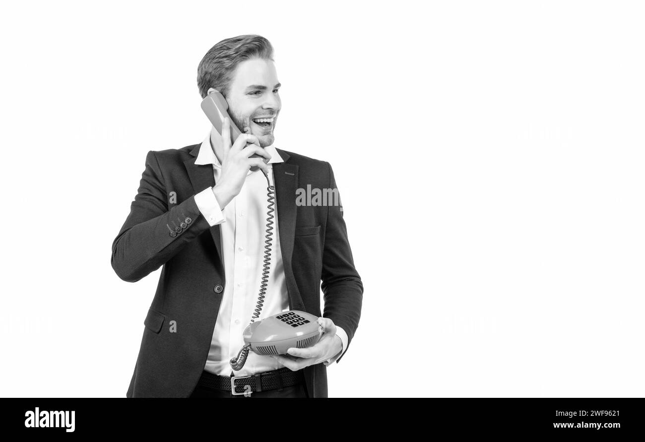 Glücklicher Mann spricht in Vintage-Telefonhörer mit altmodischem Festnetztelefon, Kommunikation Stockfoto