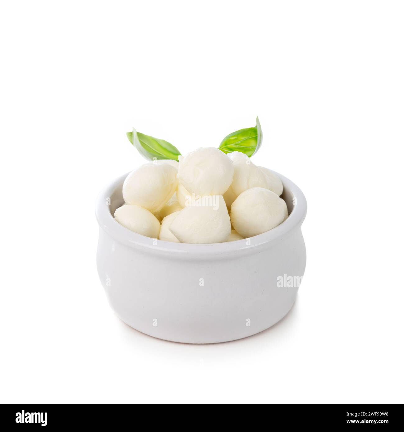 Mini-Mozzarella-Käsekugeln in einer kleinen Schüssel mit Basilikum isoliert auf weißem Hintergrund Stockfoto