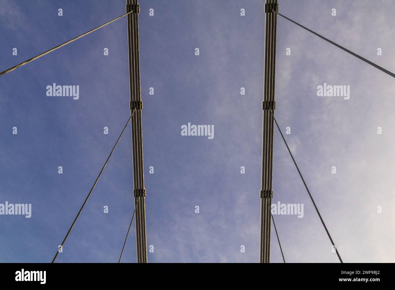 Skybound Symphony: Abstrakte Winkel von hängenden Stahlseilen erzeugen einen geometrischen Tanz, der Erde und Himmel in einer Linienbrücke verbindet Stockfoto
