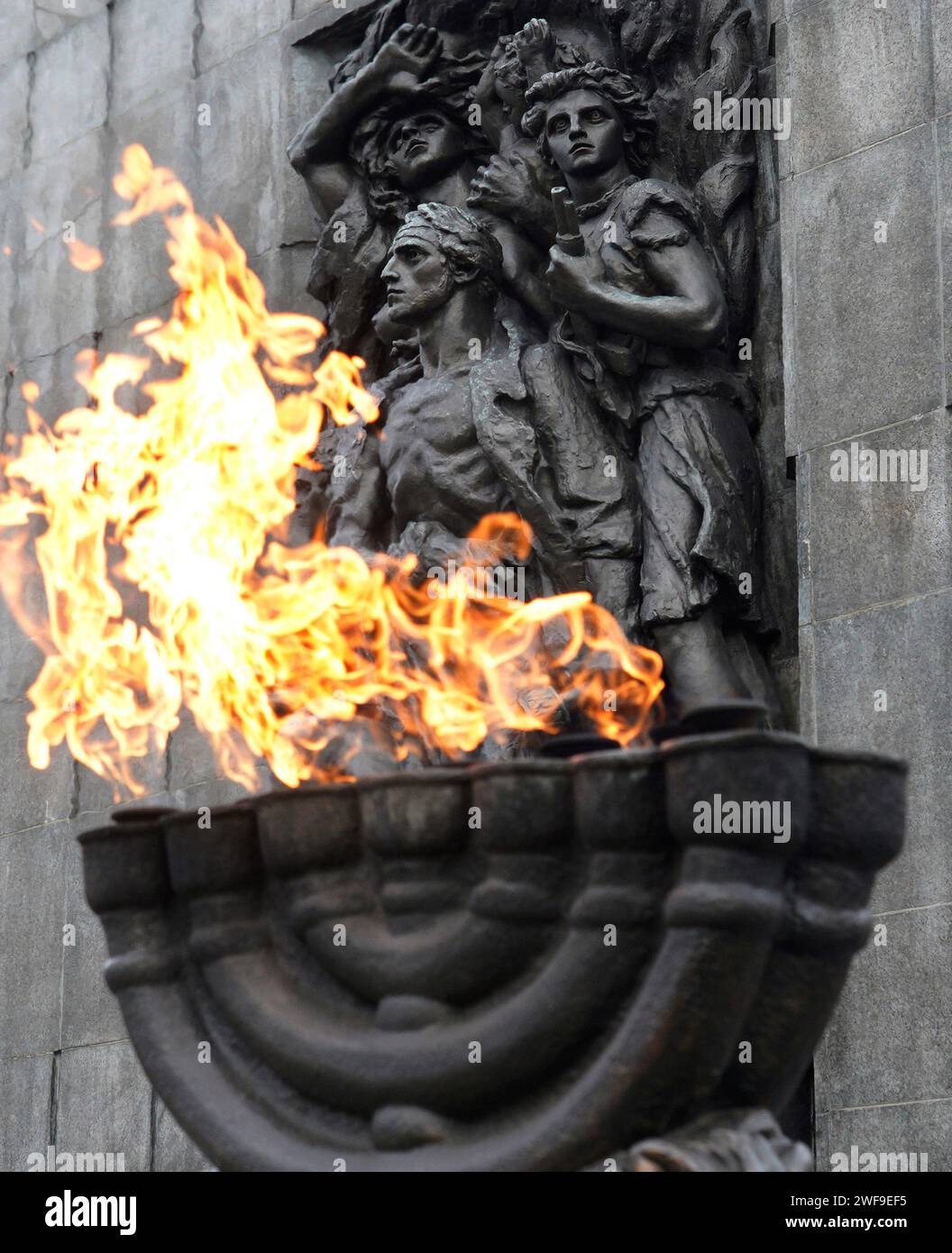 Warschau, Polen, 26. Januar 2024. Eine Menora mit Flammen vor dem Heldendenkmal des Warschauer Ghettos zum Gedenken an den Aufstand des Warschauer Ghettos 1943. Stockfoto