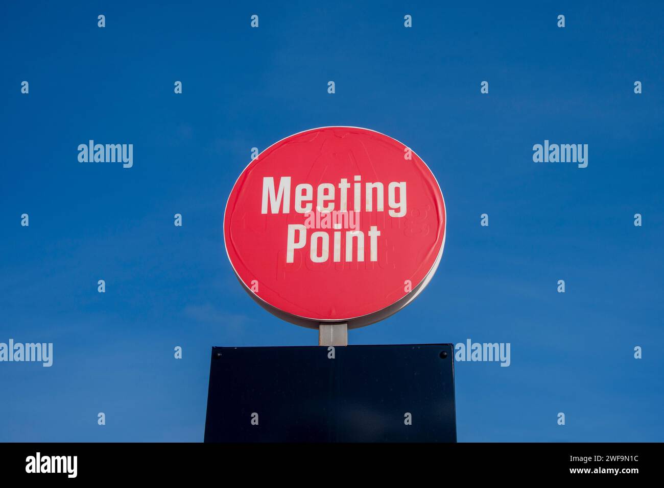 Rotes Schild mit dem Treffpunkt vor blauem Himmel Stockfoto