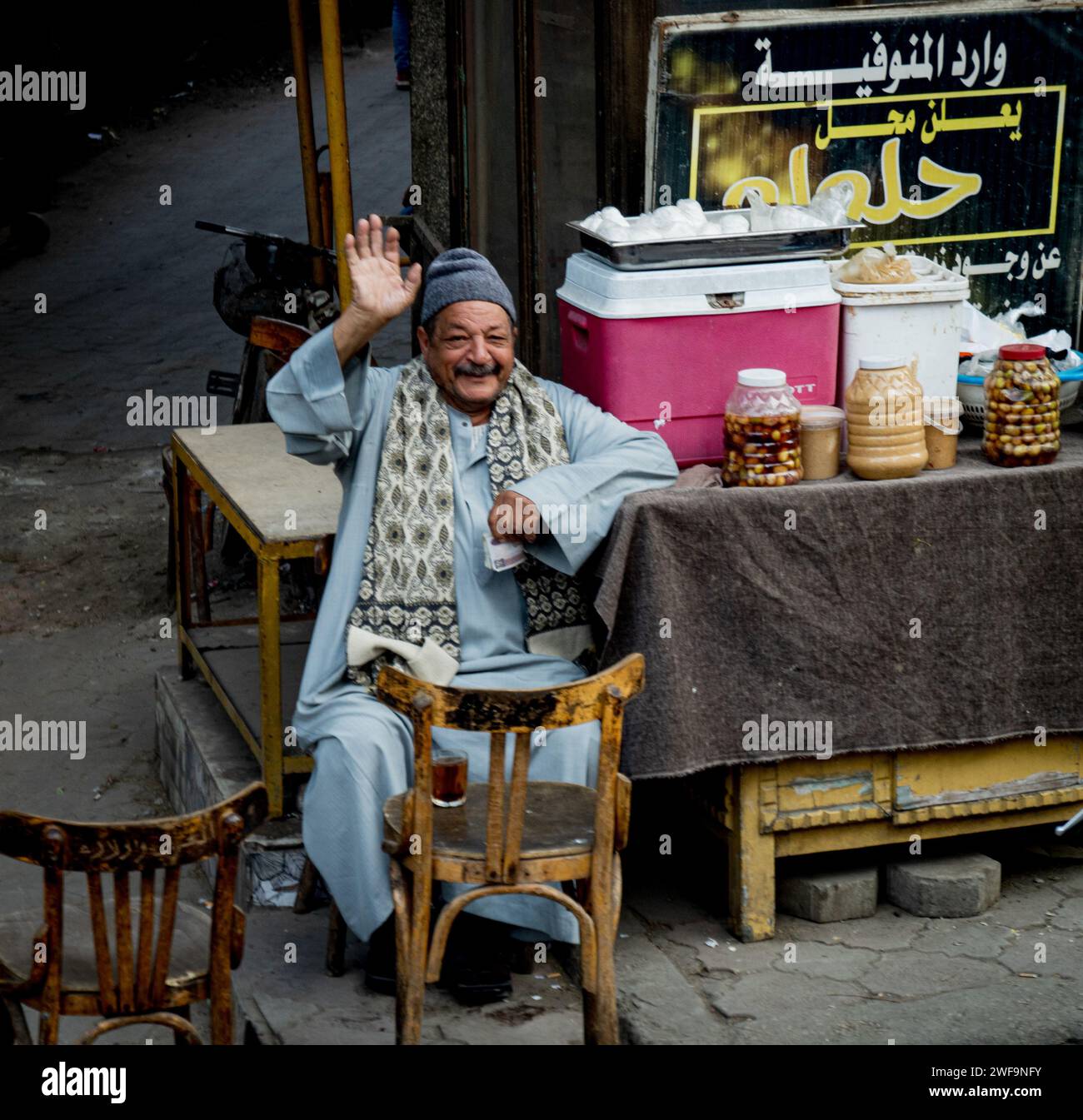 Freundlicher ägyptischer Mann, der auf dem Bürgersteig winkte und Essen verkauft Stockfoto
