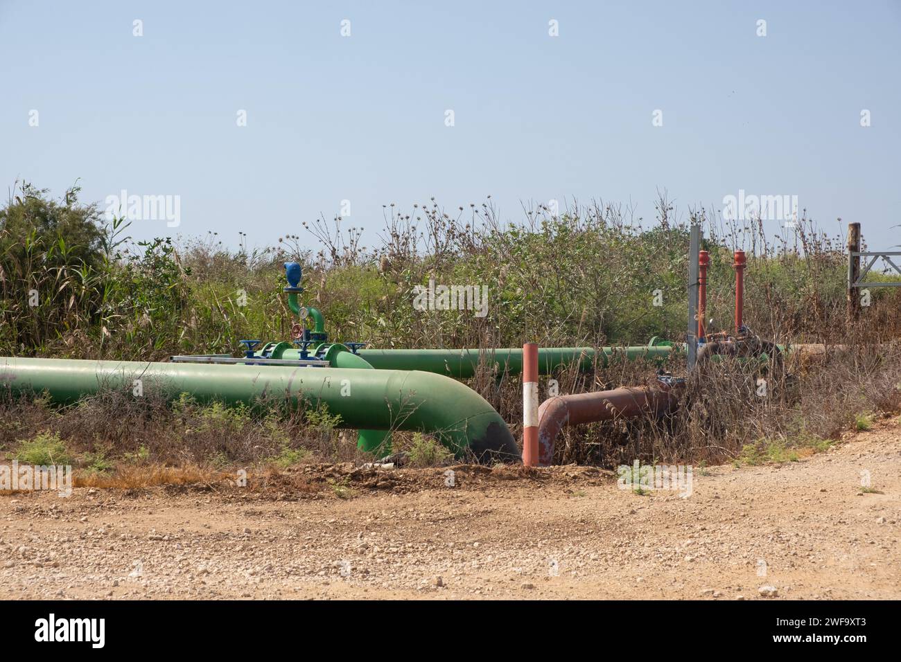 Industrielle Bewässerungsleitung zu Feldern, ein Wassersystem für landwirtschaftliche Felder. Eisenrohre verzweigen mit Wasser in trockenen Gebieten im so Stockfoto