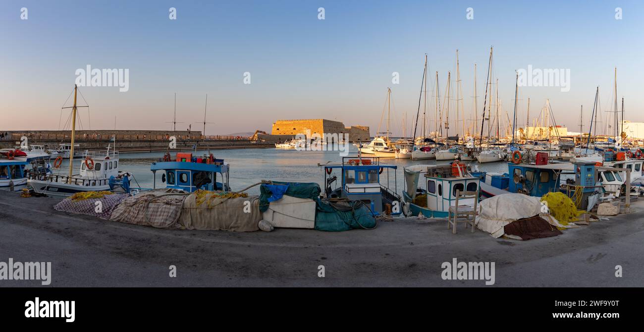Ein Foto von Fischerbooten am Yachthafen von Heraklion, mit der Rocca a Mare oder der Festung Koules in der Mitte. Stockfoto