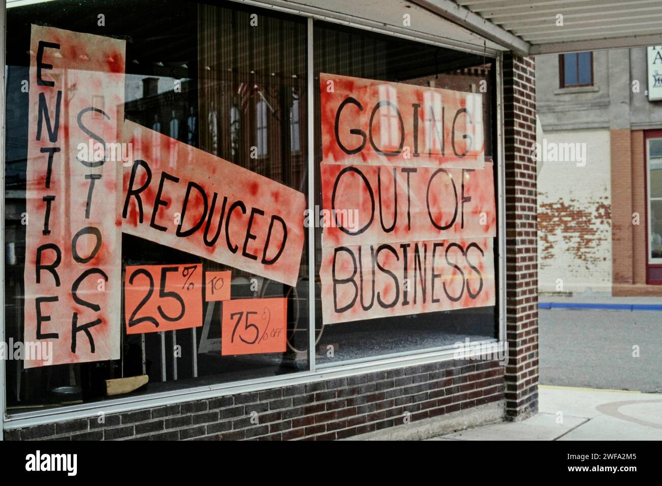 Eine Ladenfront zeigt Schilder, die den Verkauf mit reduzierten Preisen ankündigen und damit das Ende ihrer Geschäftstätigkeit markieren. Stockfoto