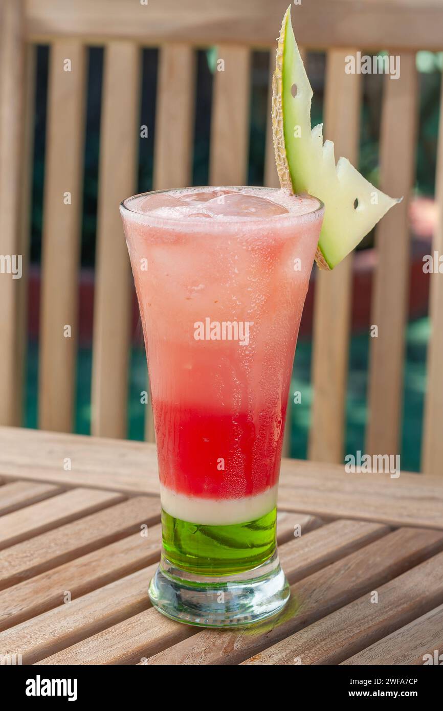 Ein Glas Melonenmocktail, serviert mit Eis und Melonenscheiben als Garnitur Stockfoto