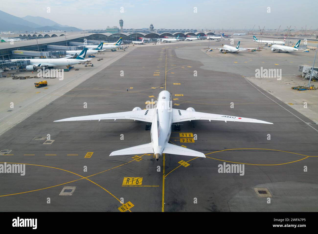 Internationaler Flughafen Chek Lap Kok mit einem geschäftigen Terminal. Flugzeuge auf dem Rollweg am Flughafen Hong Kong, auch bekannt als HKG Airport. Stockfoto