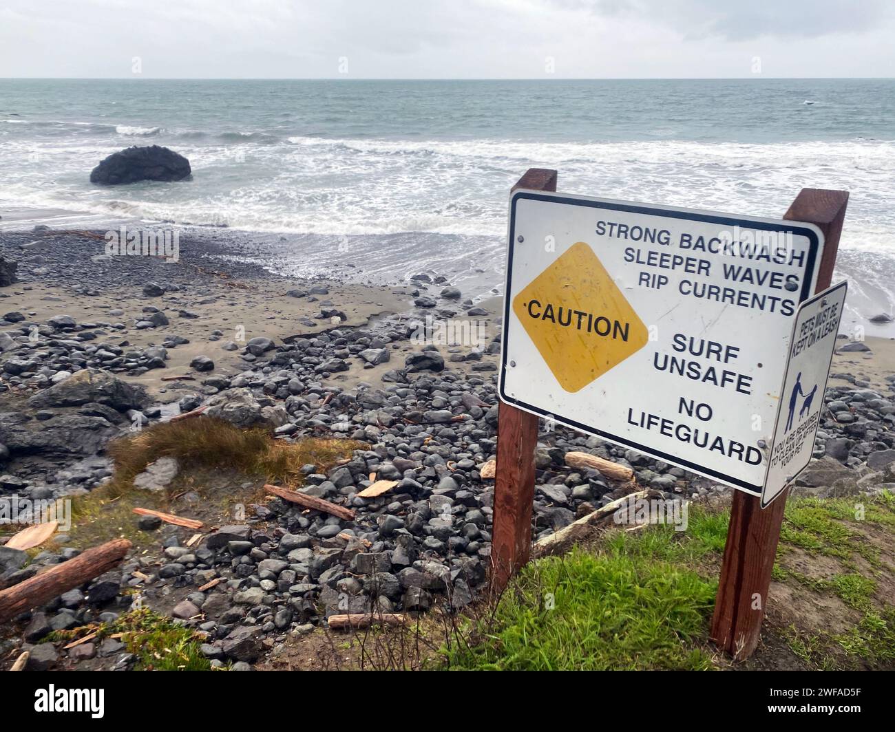 Schild an einem gefährlichen Strand: Achtung: Starke Rückspülung, Schlafwellen, Rip Current, Surf unsafe, kein Rettungsschwimmer Stockfoto