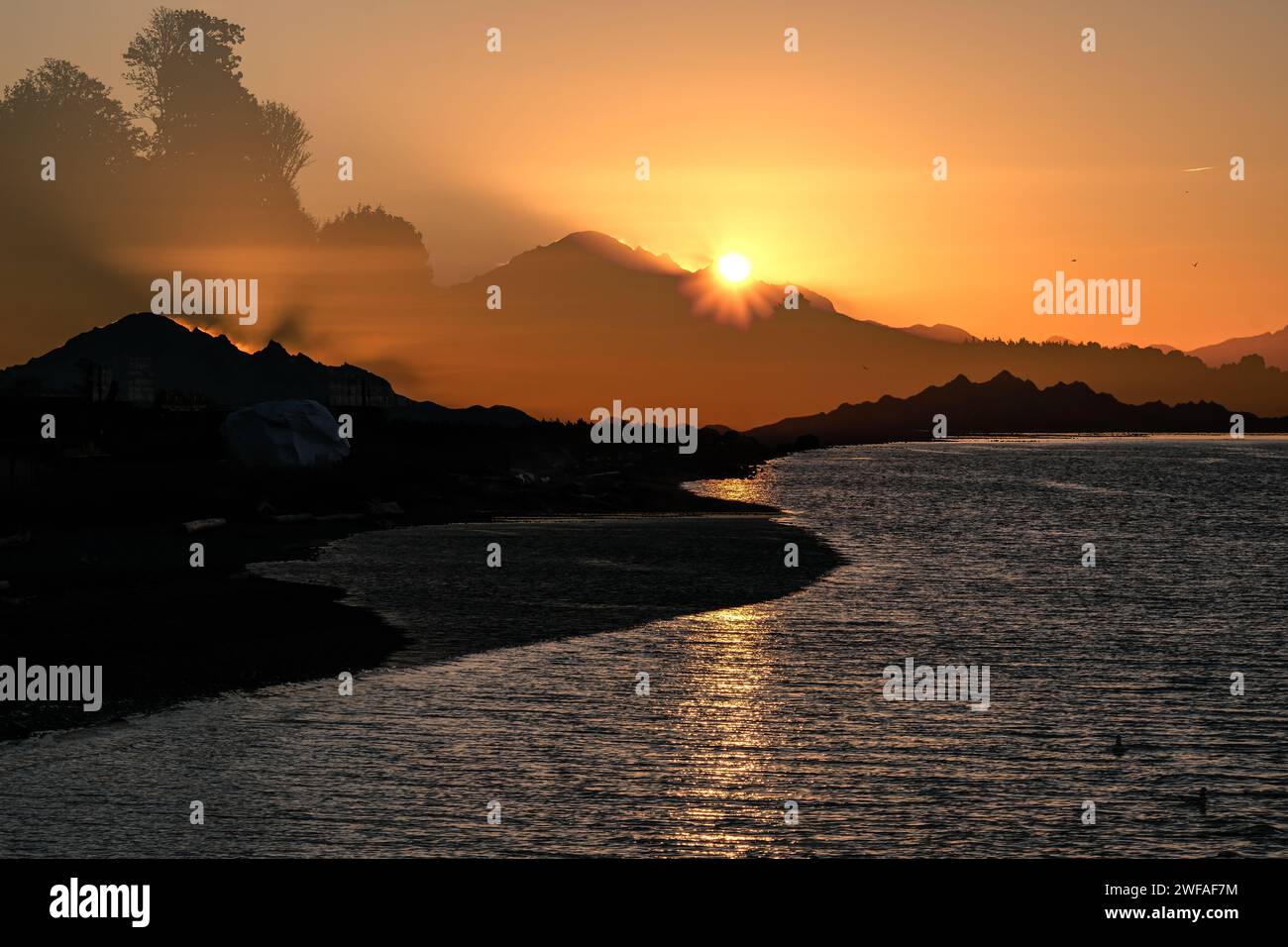 Doppelbelichtungsbild, aufgenommen während des Sonnenaufgangs vom White Rock Pier mit Blick entlang der Semiahmoo Bay in Richtung Mount Baker Stockfoto