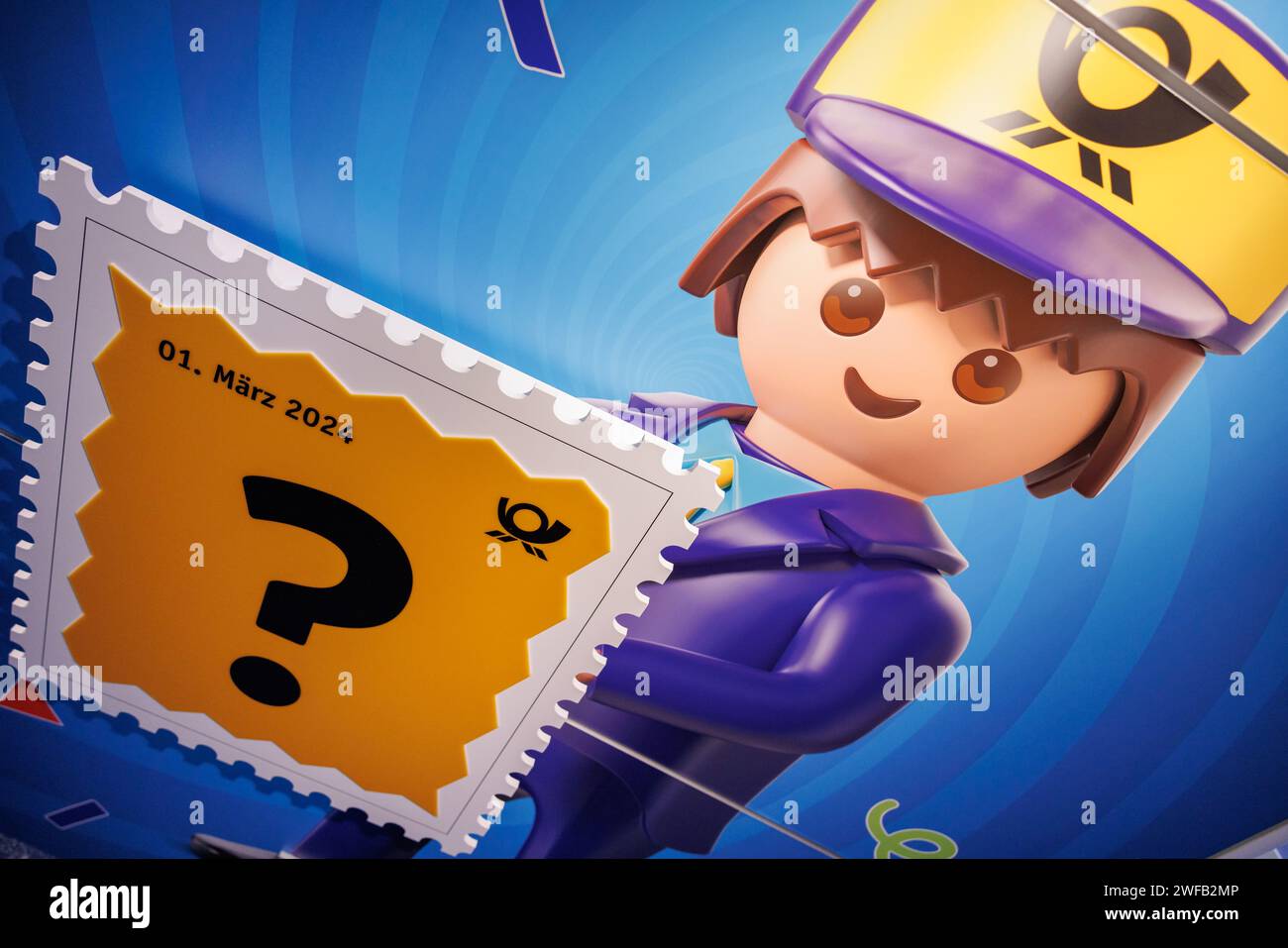 Nürnberg, Deutschland. Januar 2024. Ein Fragezeichen ziert einen übergroßen Stempel neben einer Playmobil-Figur am Playmobil-Stand. Im März 2024 wird das Unternehmen gemeinsam mit der Deutschen Post eine eigene Briefmarke herausgeben. Das Motiv bleibt bis dahin geheim. Die erste dieser Spielzeugfiguren kam vor 50 Jahren auf den Markt und eroberte in den nächsten Jahrzehnten Kinderzimmer in vielen Ländern der Welt. (Zu dpa KORR: '50 Jahre Playmobil - vom Kindergarten zum Sammlerstück') Credit: Daniel Karmann/dpa/Alamy Live News Stockfoto