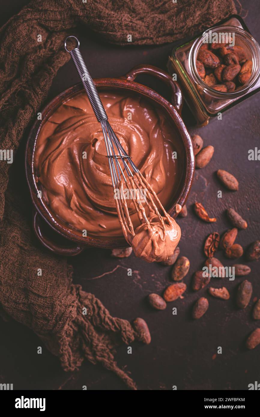 Schokoladen-Frischkäse-Mousse in einer Schüssel mit Schneebesen, gesunde hausgemachte zuckerfreie Snacks Stockfoto
