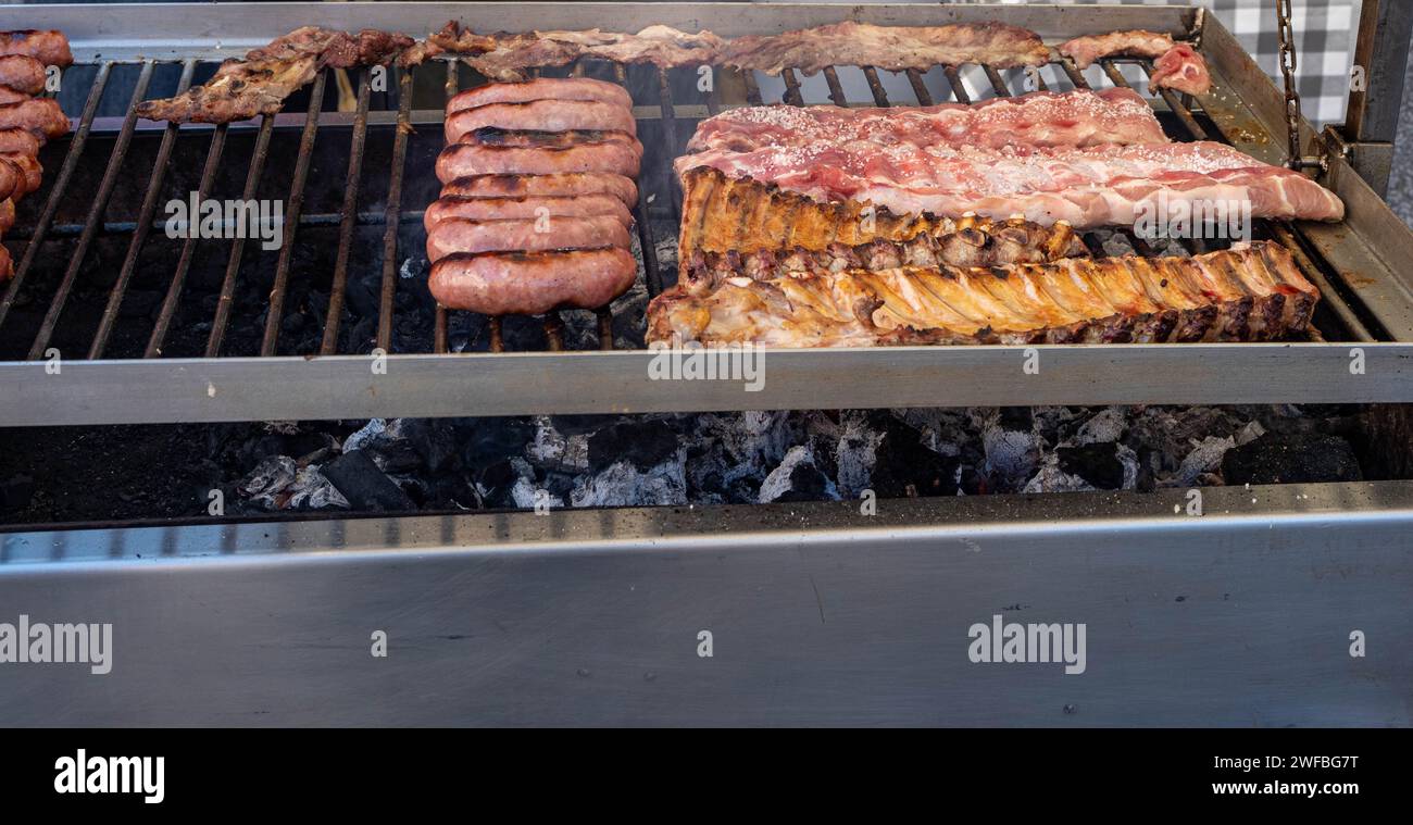 Gegrillte Würstchen auf dem Straßenmarkt auf einer mittelalterlichen Messe in Spanien. Würstchen, Schwarzpudding und scharfe Würstchen zum Essen. Stockfoto