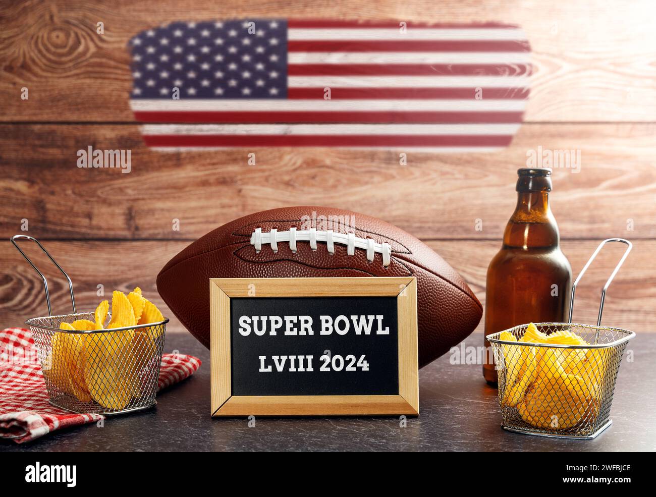 27. Januar 2024: Der 58. Super Bowl, Fußball umgeben von Snacks und Bier und USA-Flagge mit einer Plakette mit der Aufschrift Super Bowl LVIII 2024 FOTOMONTAGE *** der 58. Super Bowl, Football umgeben von Snacks und Bier und USA Flagge mit einer Tafel mit der Aufschrift Super Bowl LVIII 2024 FOTOMONTAGE Stockfoto