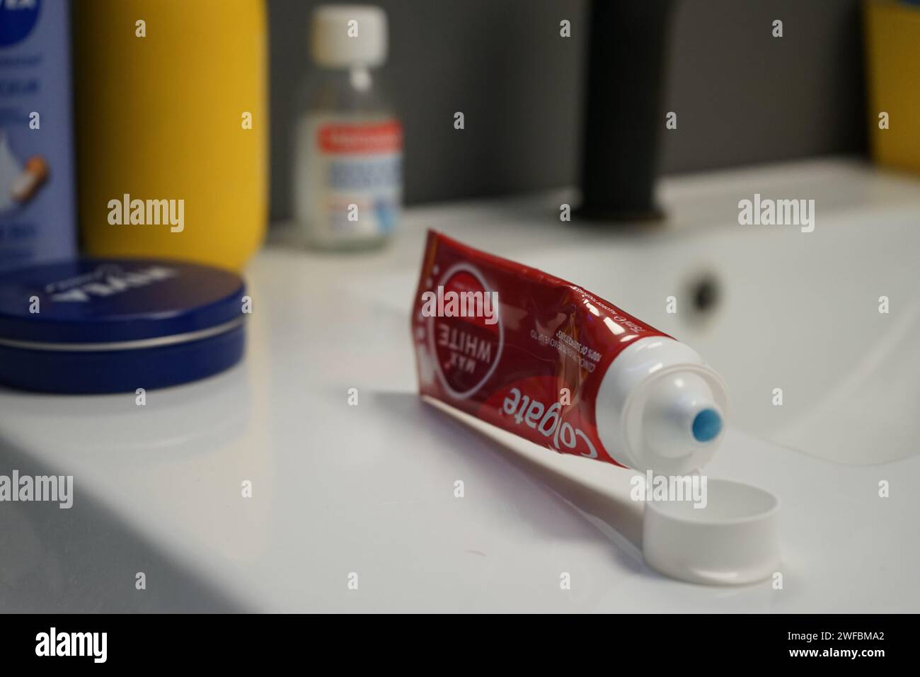 Colgate Zahnpasta öffnete sich neben anderen Körperprodukten auf einer Badezimmertheke Stockfoto