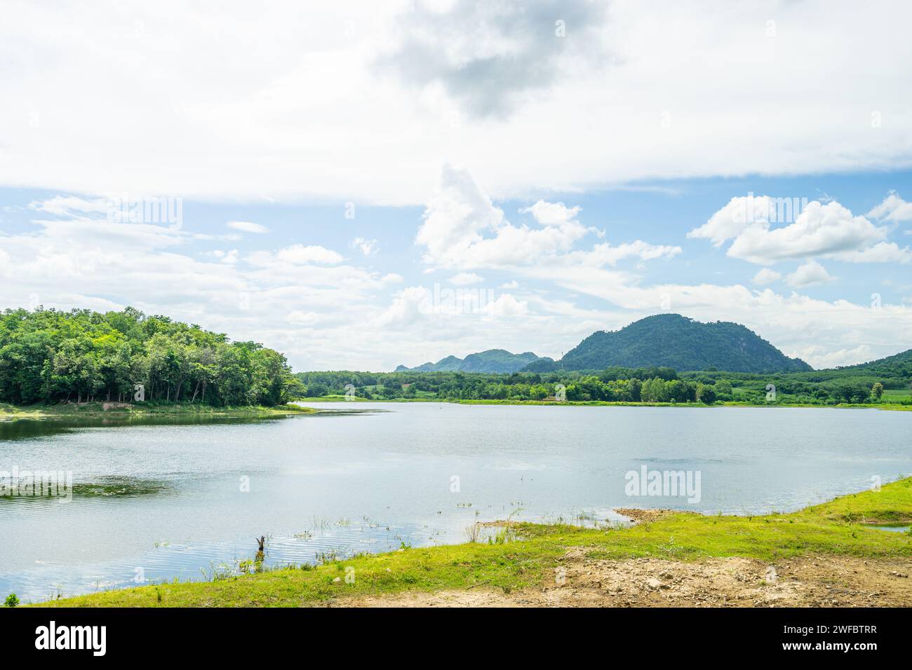 Wasserreservoir mit grünem Wald und kleinem Berg im Hintergrund in der lokalen Gegend namens Huay Pha Wang in A Wang District, Nong Bua Lam Phu, Thailand Stockfoto