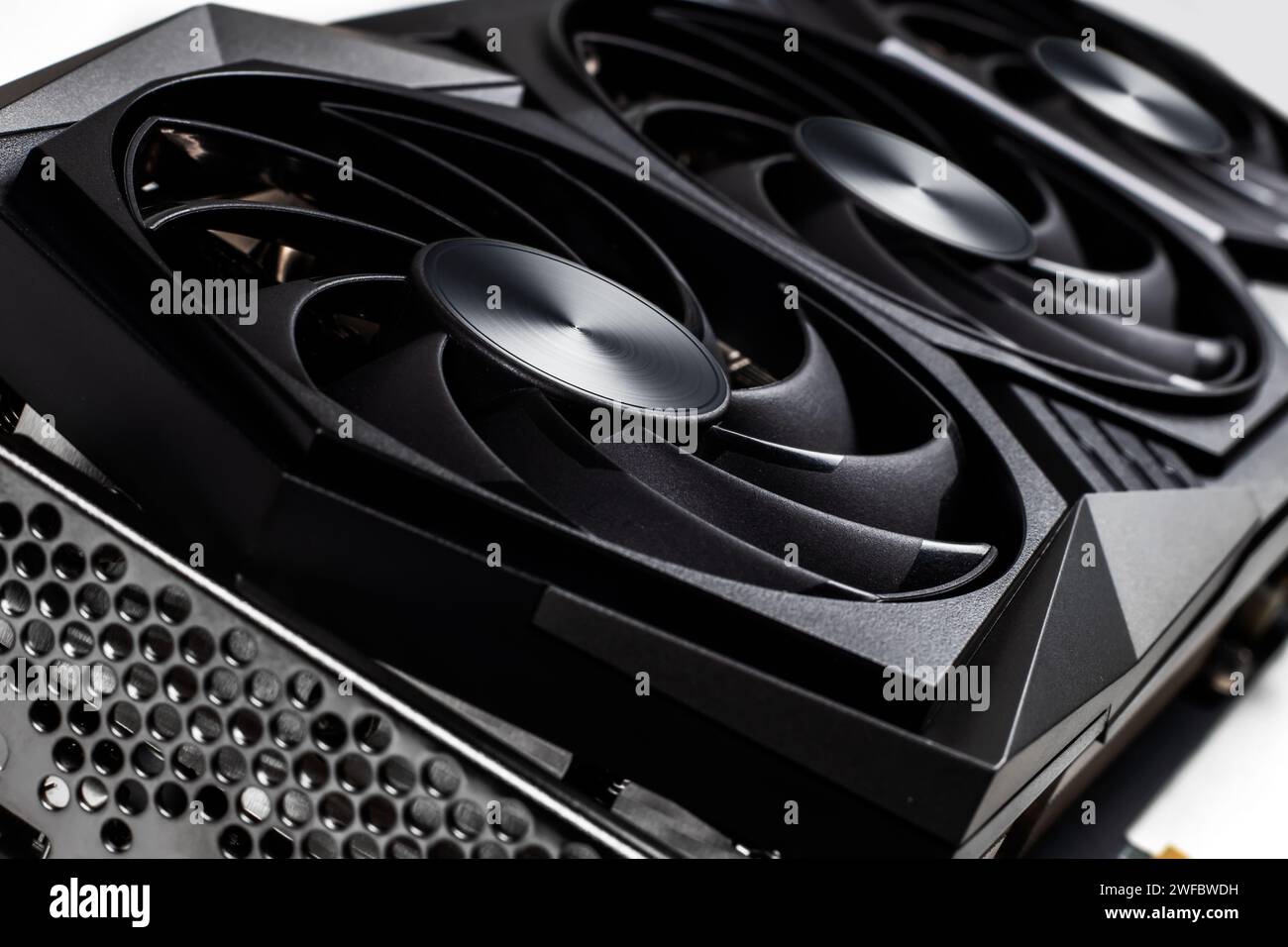 Video-Grafikkarte mit leistungsstarker GPU auf weißem Hintergrund. Professionelle Videokarte für Computer. Nahaufnahme mit geringer Schärfentiefe. Stockfoto