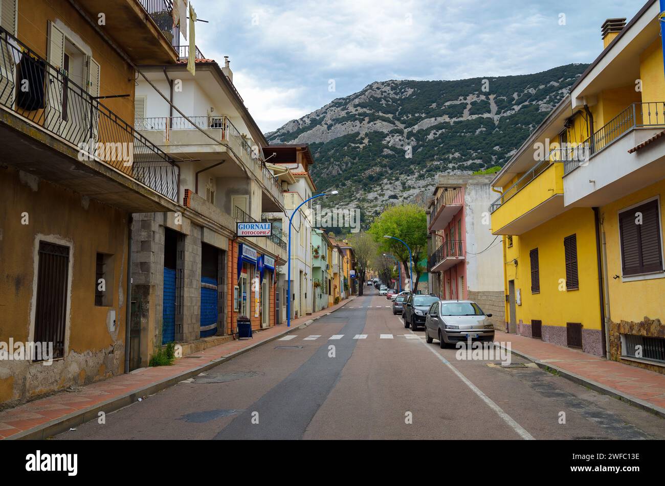 Ruhige Straße in Dorgali, Sardinien mit farbenfrohen Gebäuden und Bergkulisse Stockfoto