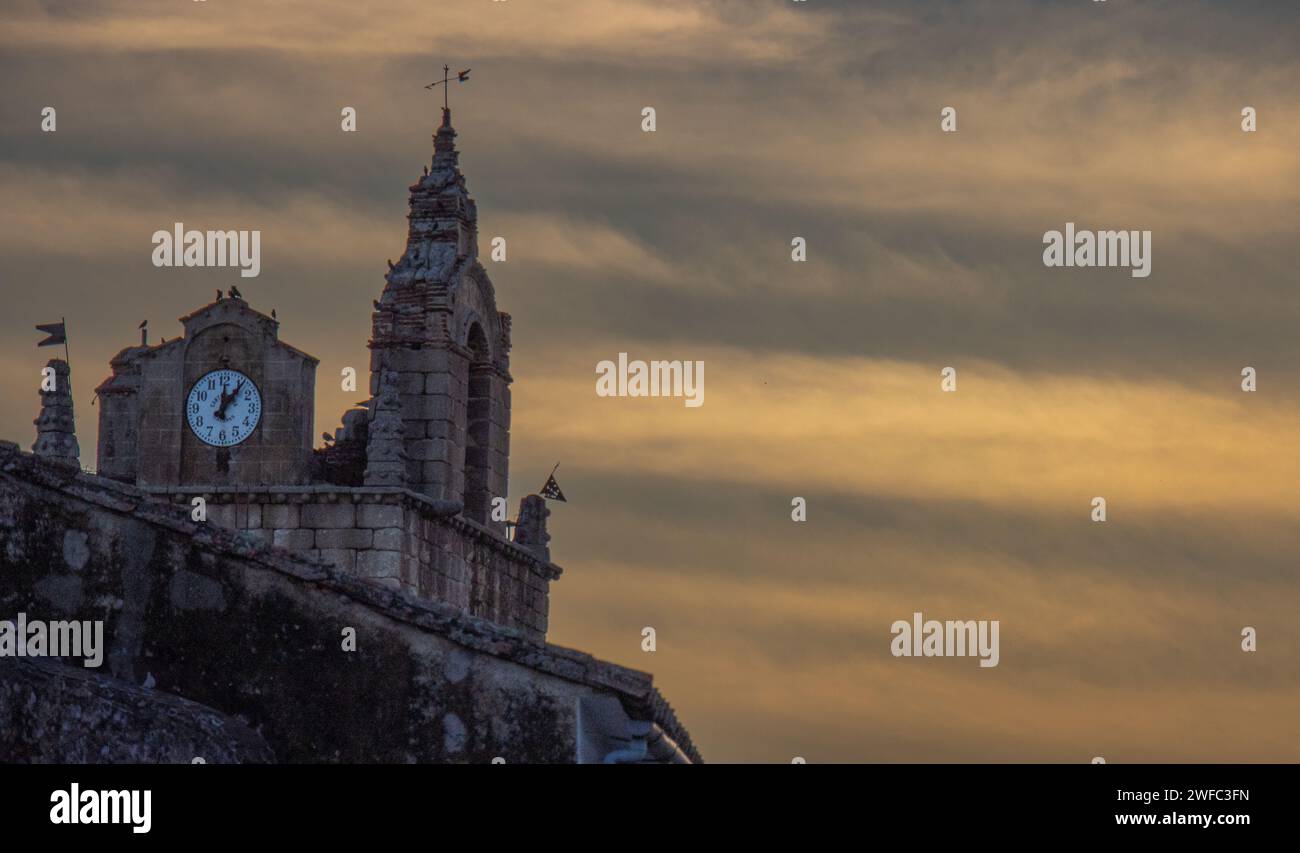 Colores en el cielo del atardecer y detalle de la torre de la iglesia de Santa Marina en Cañaveral, Cáceres, España Stockfoto