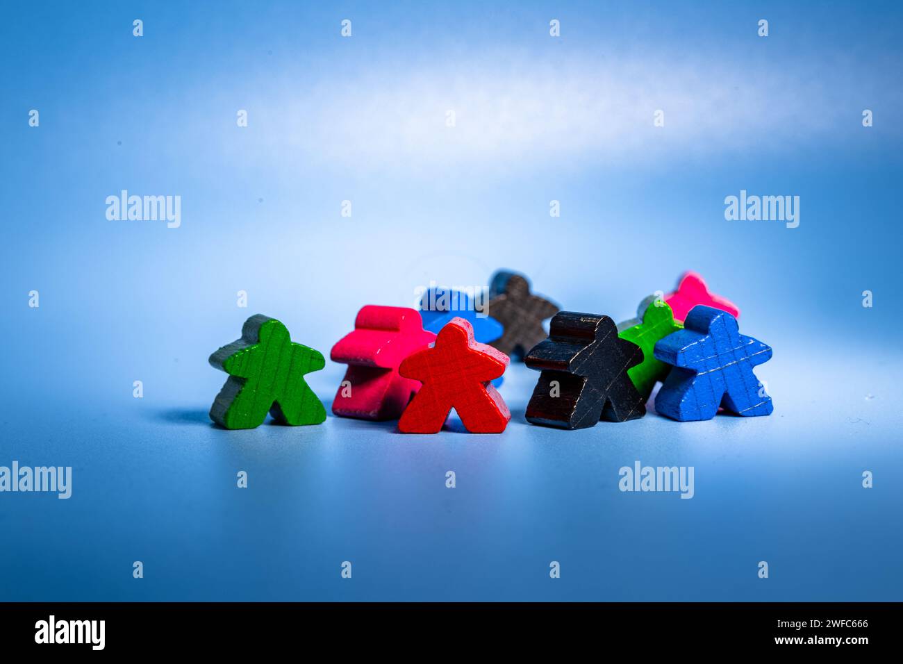Eine Sammlung von Miniaturfiguren, die auf einem leuchtend blauen Hintergrund angeordnet sind Stockfoto